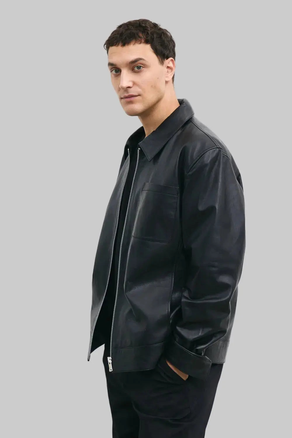 LEFT SIDE POSE Men's black leather jacket made from premium full grain leather with front zipper closure, classic collar, and modern minimalist design by LEATHERTEXEU.